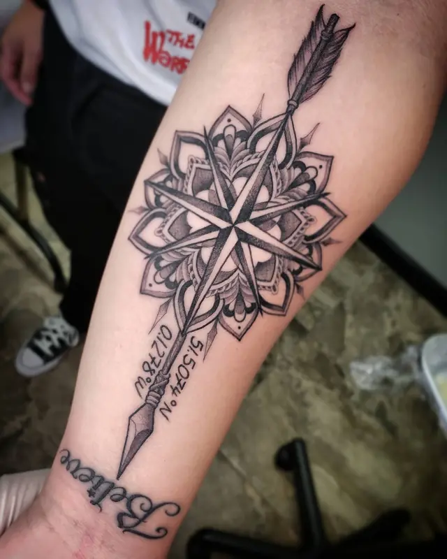 Black and gray compass, arrow and mandala forearm tattoo with script by Chris Carp at Heart & Sword Tattoo